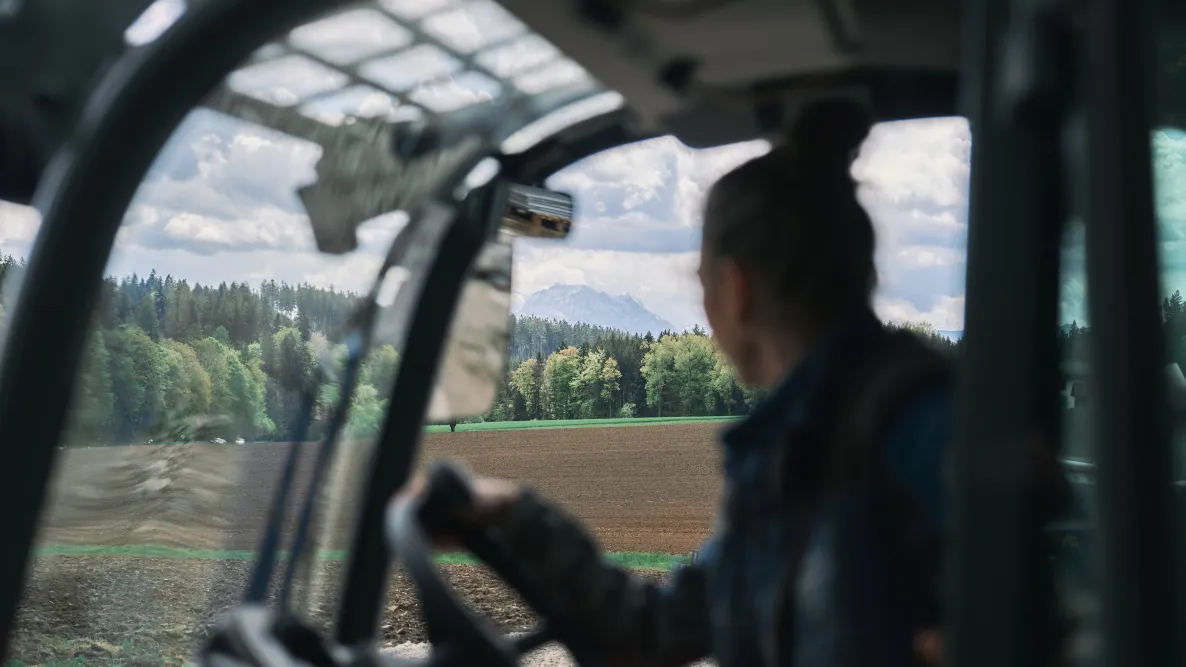 Barbara Holzinger blickt aus einem Fahrzeug auf ein Feld